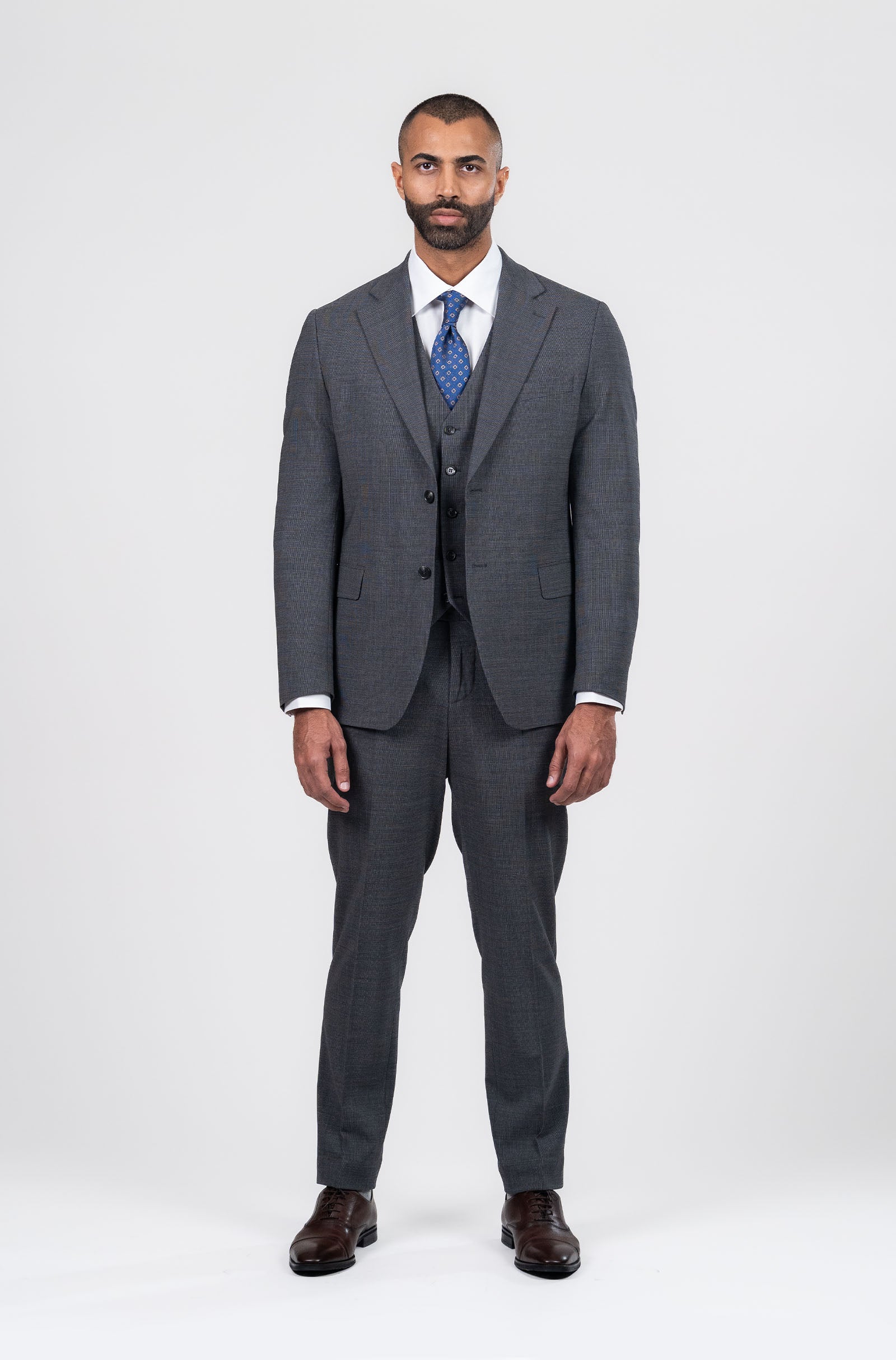 Man wearing a gray suit with a blue tie on a white background