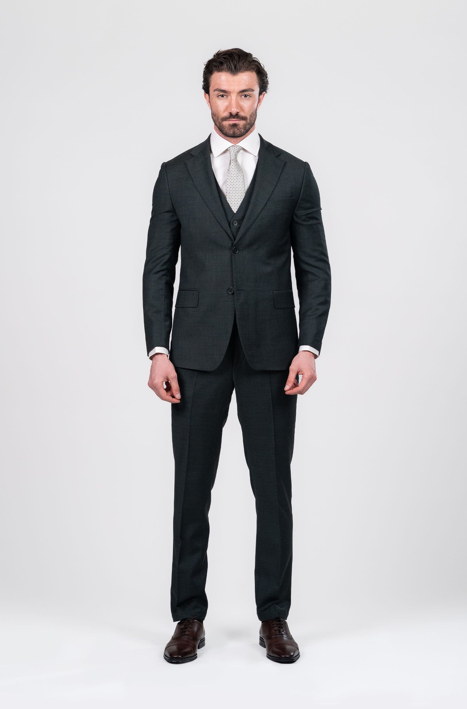 Man wearing an olive suit with a white shirt on a white background